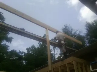 Carpenter setting a ridge beam over a new addition frame — Ice Dam Removal by Roofing Brothers in Esopus