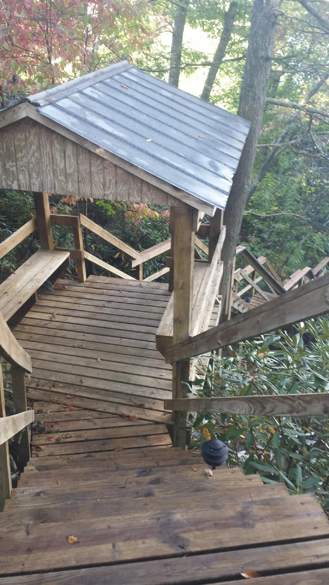 Metal roofed shelter over wooden steps on a wooded walkway — Skylight Repair & Installation work by our crew in Esopus